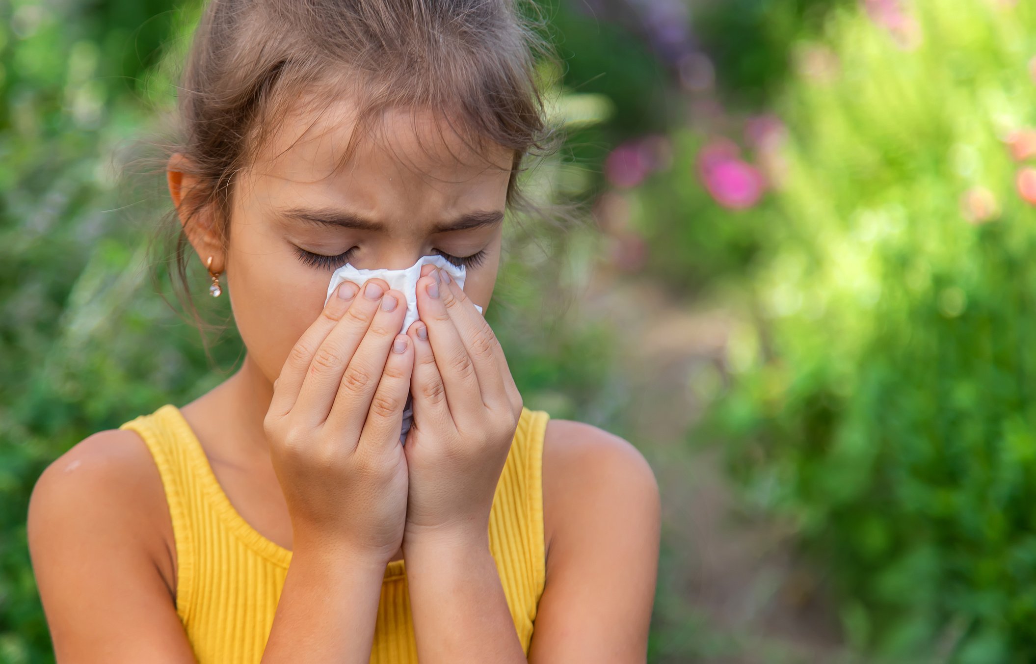 Girl Sneezing With Tissue On Mouth