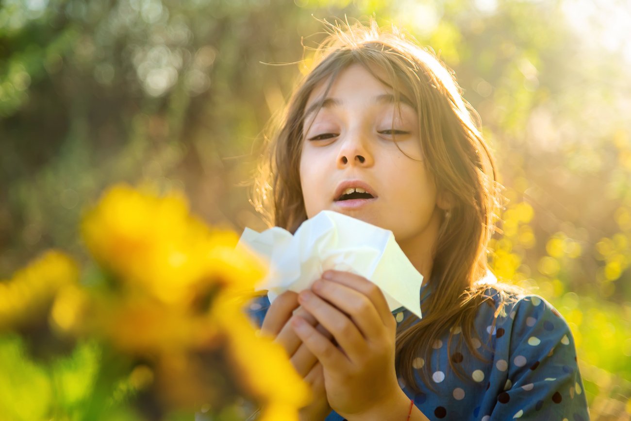 Girl Holding Tissue Paper Sneezing In Garden